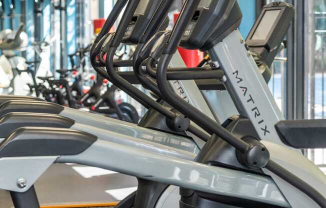 a row of cardio machines in a gym