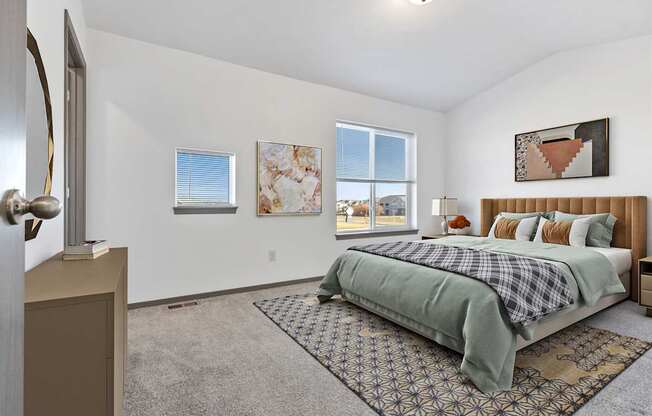 A bedroom with a bed, a dresser, and a window.