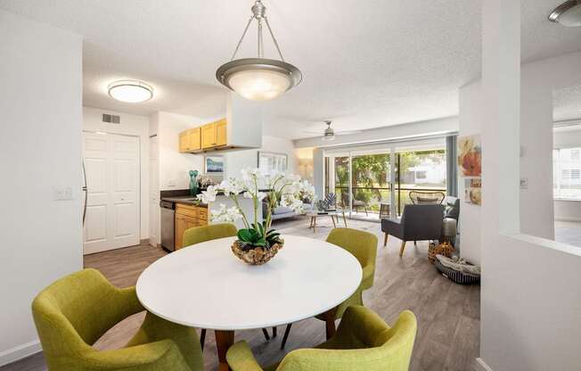 a dining room with a white table and green chairs