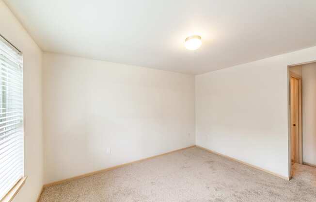 a bedroom with white walls and carpet