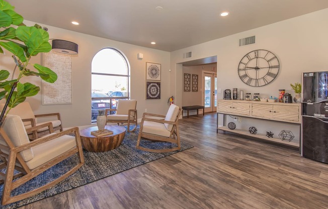 A living room with a wooden floor and a large clock on the wall.