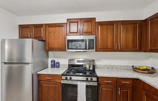 A kitchen with a stove, refrigerator, and cabinets.