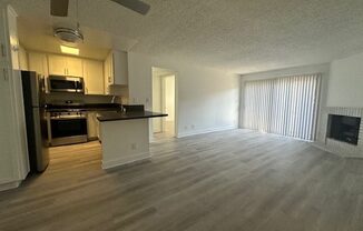 an empty kitchen and living room with wood floors