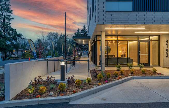 a view of the front entrance of a building with a sunset in the background