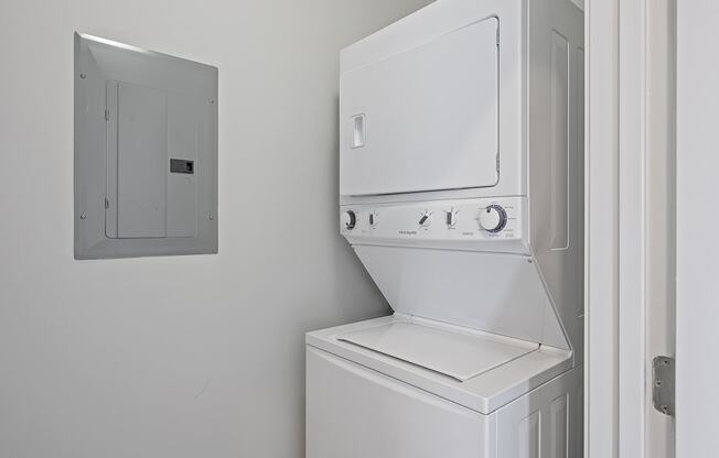 a white washer and dryer in a white laundry room with a white door