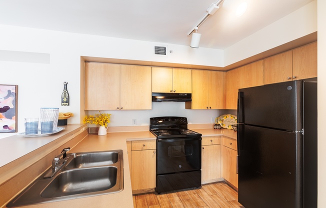 a kitchen with black appliances and wooden cabinets