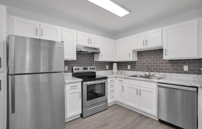 a kitchen with white cabinets and stainless steel appliances