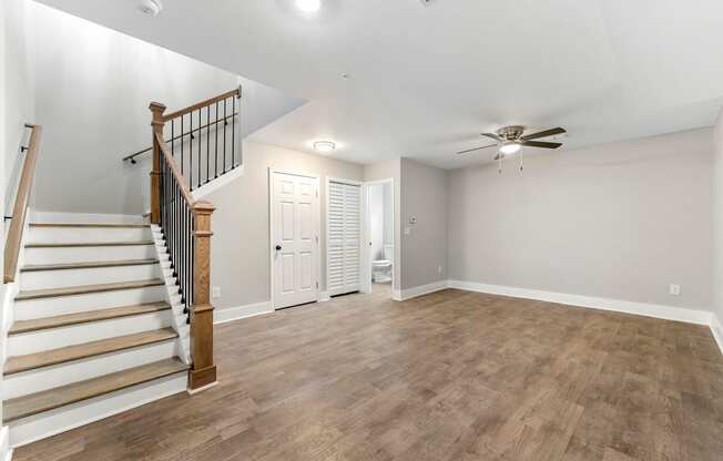 Living room with a staircase and a ceiling fan at Crogman School Lofts, Atlanta, 30315