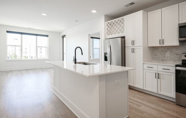 a large white kitchen with white cabinets and a white counter top