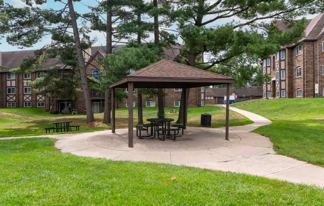 a picnic area with a gazebo in front of an apartment building