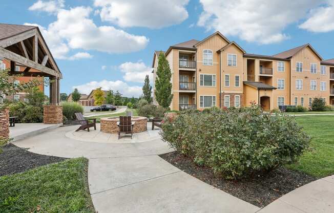 an outdoor patio with a fire pit in front of an apartment building