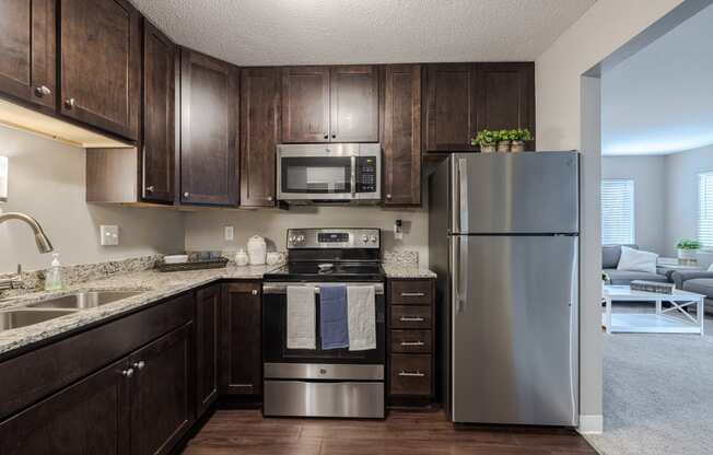 a kitchen with stainless steel appliances and dark wood cabinets