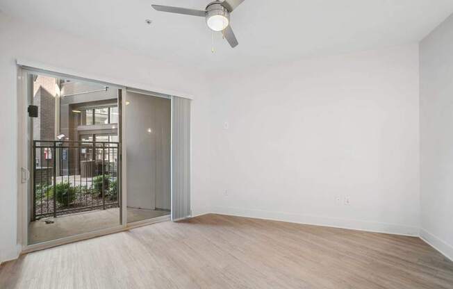A room with a sliding glass door leading to a balcony.