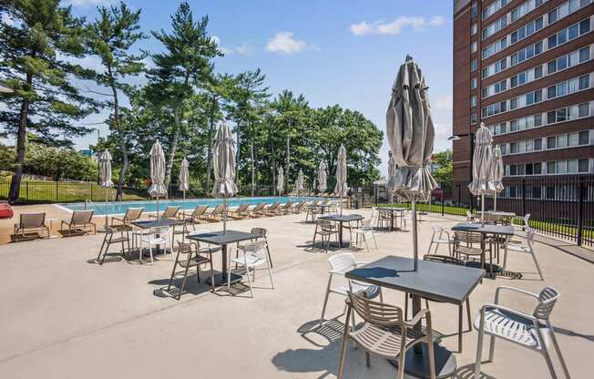 an outdoor patio area with tables and chairs and a swimming pool