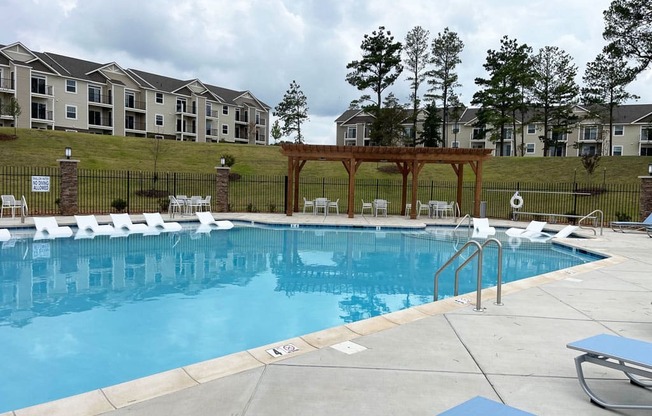 a swimming pool with large sundeck and plenty of seating areas at Signature Pointe Apartment Homes, Athens, AL