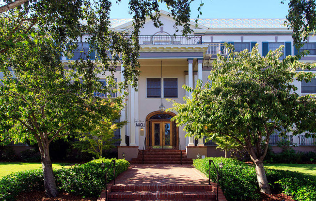 a large white building with trees in front of it