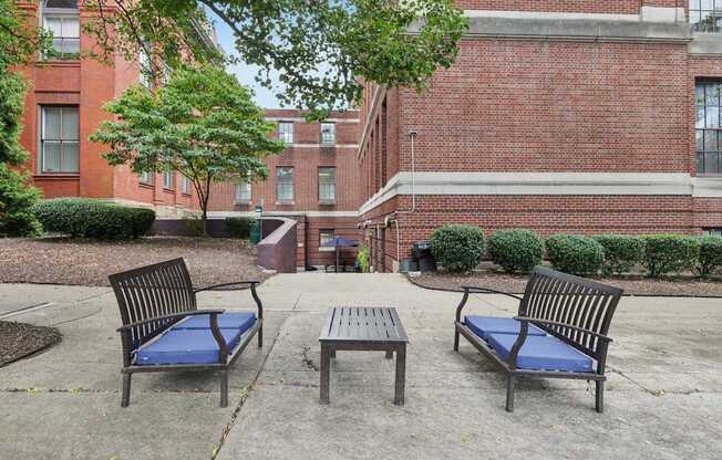 A park area with a bench, table and a tree.