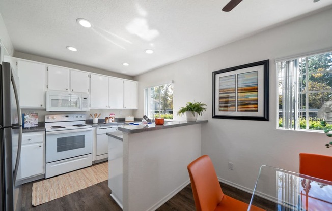 a kitchen and dining room with white appliances and white cabinets