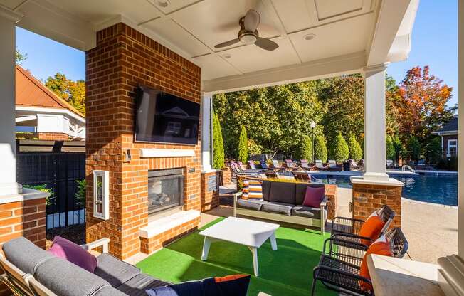 a backyard with a fireplace and a pool with lounge chairs and a table