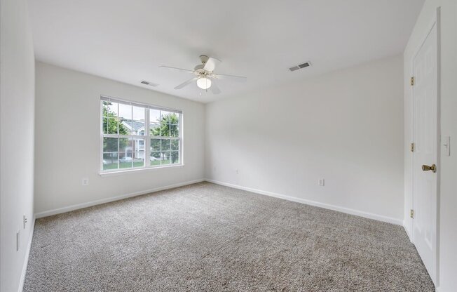 Spacious Carpeted Bedroom with Large Window