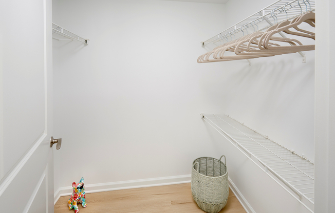 This spacious walk-in closet is upgraded with new vinyl plank wood-style flooring, providing a clean and modern look that extends from the primary bedroom.