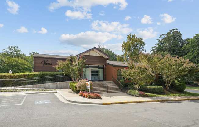 A building with a brown roof and a black fence in front of it.