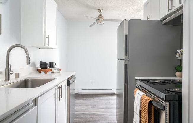 a kitchen with white cabinets and a stainless steel refrigerator