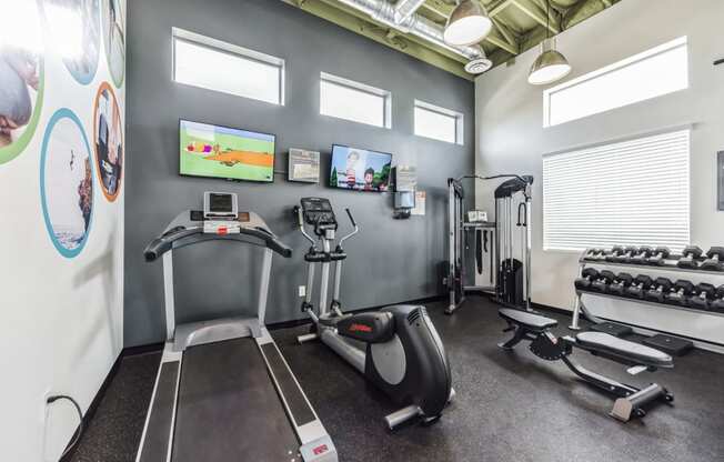 gym with exercise equipment and tv at the district flats apartments in lenexa