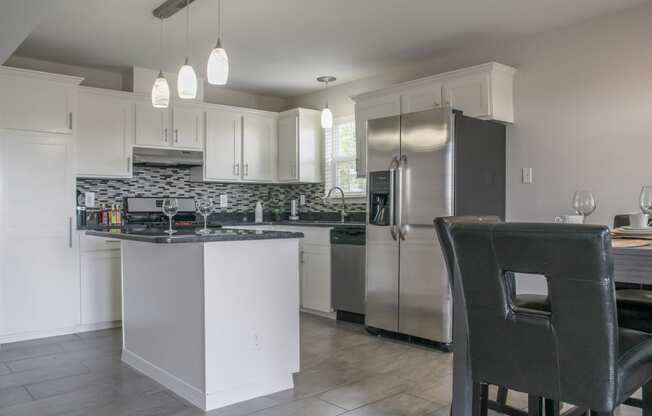 a kitchen with white cabinets and stainless steel appliances at Village of Cottonwood Springs, El Paso TX