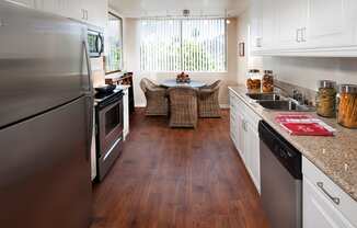 a kitchen and dining room with stainless steel appliances and a table