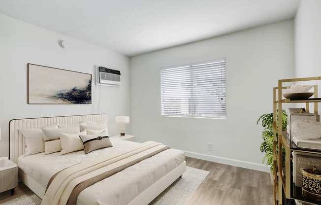 A bedroom with a large bed and a painting on the wall.