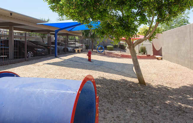 a playground with a blue tarp and a red fire hydrant