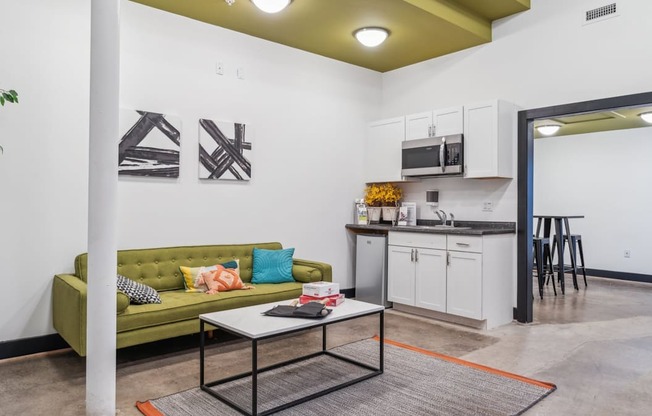 A living room with a green couch and a coffee table.