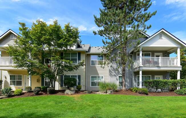 the view of an apartment building with a lawn and trees