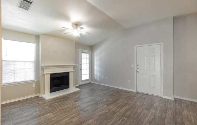 an empty living room with a fireplace and a white door