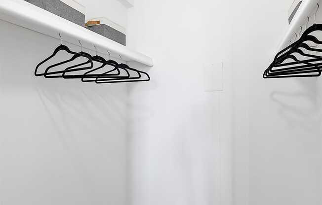 a white closet with shelves and hooks on the wall at Troy Place Apartments - Troy, MI, Troy, Michigan