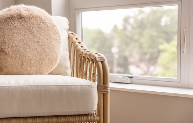 a chair with a white cushion next to a window
