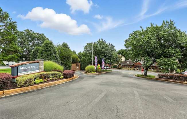 A sign that says Mooresville stands in front of a road.