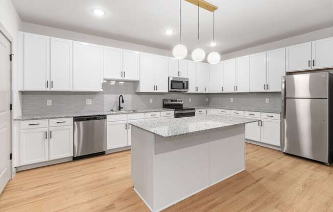A modern kitchen with a central island and stainless steel appliances.