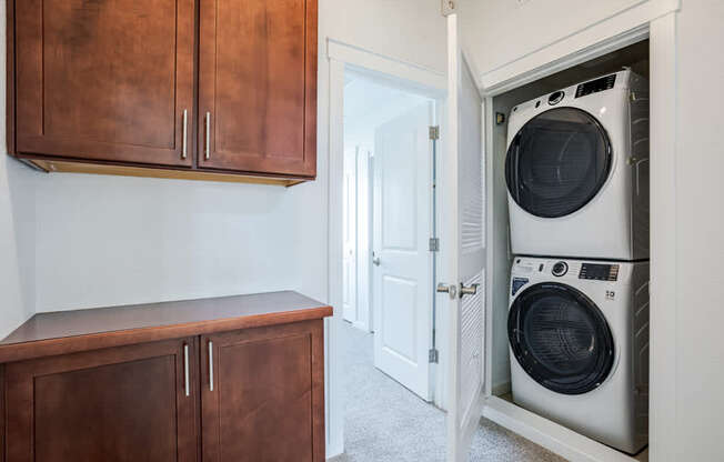 A white washing machine is in a cabinet in a room.