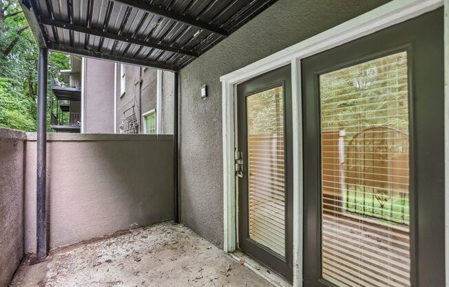 A patio with a sliding glass door and a metal roof.