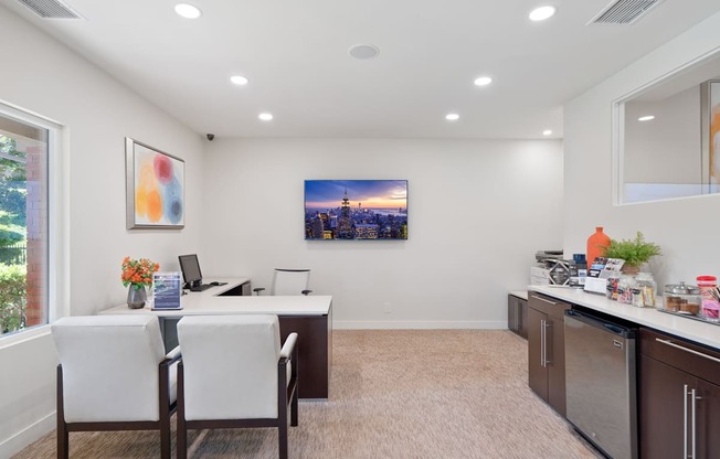 a white office with a desk and chairs and a window