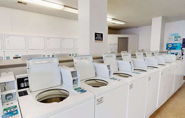 A row of washing machines are lined up in a laundromat.