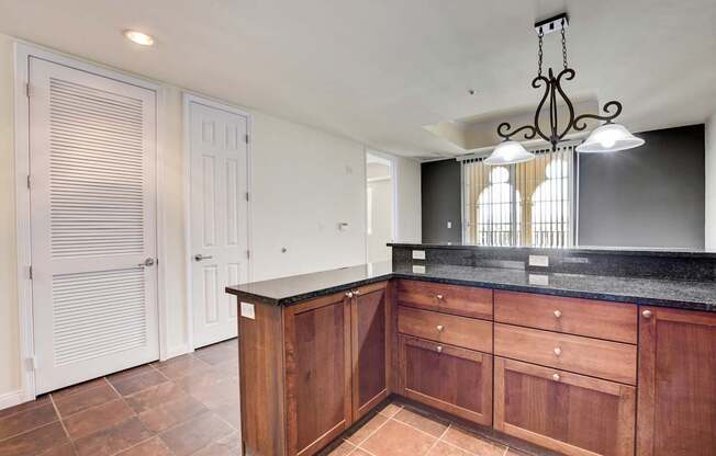 A kitchen with wooden cabinets and a black countertop.