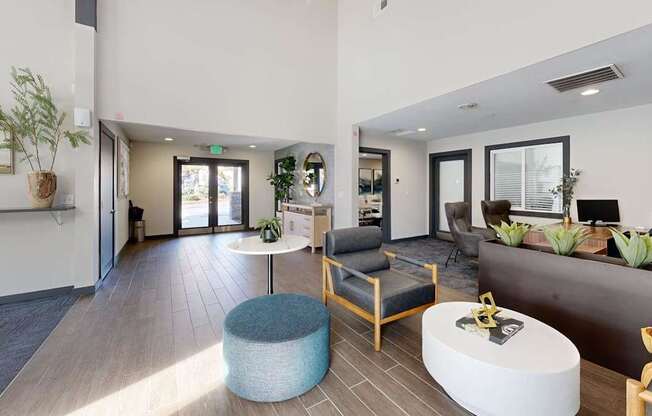 A modern waiting room with a blue ottoman and wooden chairs.
