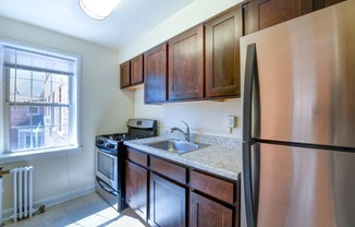 kitchen with espresso cabinetry, stainless steel appliances and large window at hillside terrace apartments in washington dc