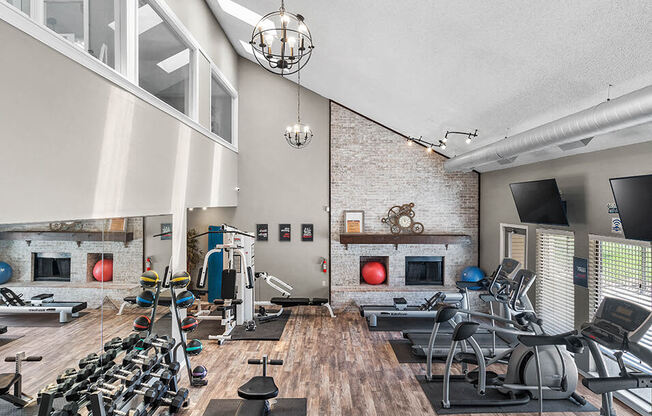 the gym in the loft has plenty of exercise equipment and a large window