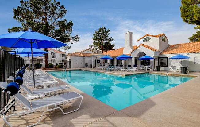 a swimming pool with lounge chairs and umbrellas