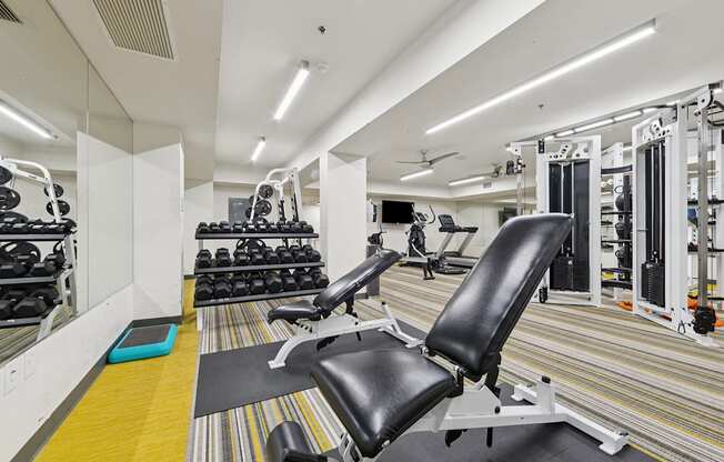 A gym with a variety of equipment including weights and machines.