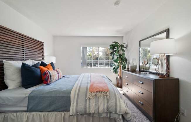 a bedroom with a bed and a dresser and a window